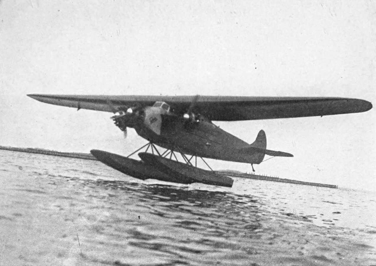 Photo wide shot of tri-motor airplane taking off from water