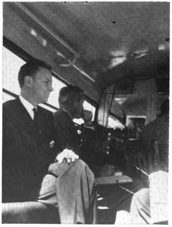 A man sitting in the back of a vehicle with aother couple of passengers near him