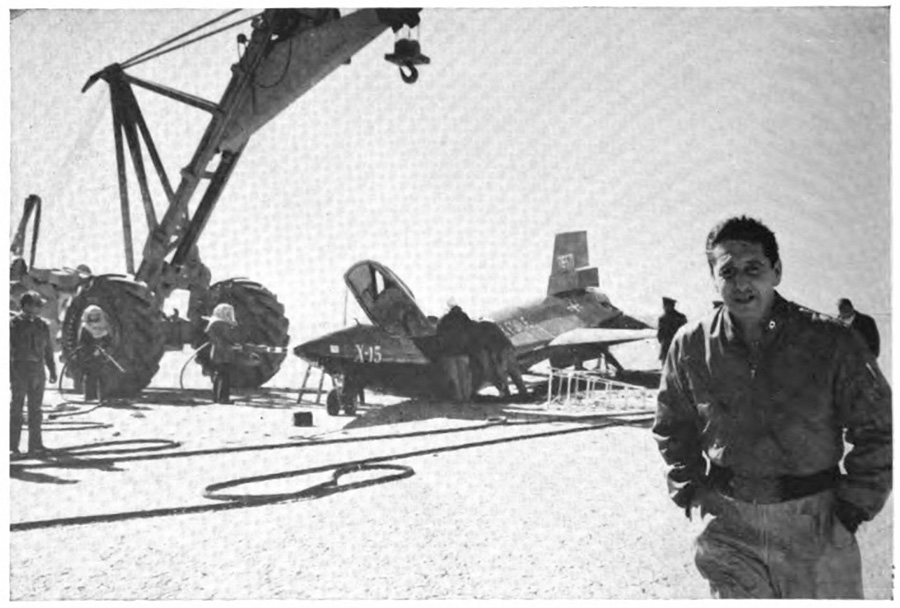 A man walking away from a plane that a couple of men are working on
