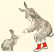 Child in bunny suit feeding a bunny