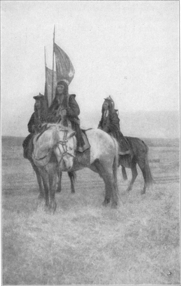 Three women on horseback, two of whom are carrying banners.