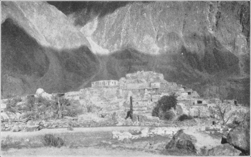 Stone buildings at the foot of a mountain.