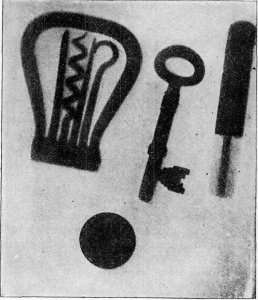 CORK-SCREW, KEY, PENCIL WITH METALLIC PROTECTOR, AND PIECE OF COIN, AS PHOTOGRAPHED WHILE INSIDE A CALICO POCKET.