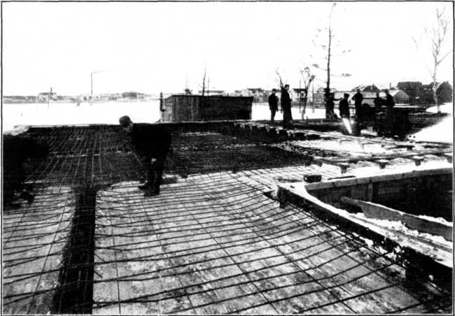 Reinforcement in Place Over One Complete Floor of Storage Warehouse. Slabs, 14 Ft. Square. Reinforced Two Ways. Note Continuity of Reinforcement and Elevation Over Supports. Floor Designed for 150 Lb. per Sq. Ft. Live Load. Tested to 900 Lb. per Sq. Ft. Reinforcement in Place Over One Complete Floor of Storage Warehouse. Slabs, 14 Ft. Square. Reinforced Two Ways. Note Continuity of Reinforcement and Elevation Over Supports. Floor Designed for 150 Lb. per Sq. Ft. Live Load. Tested to 900 Lb. per Sq. Ft.