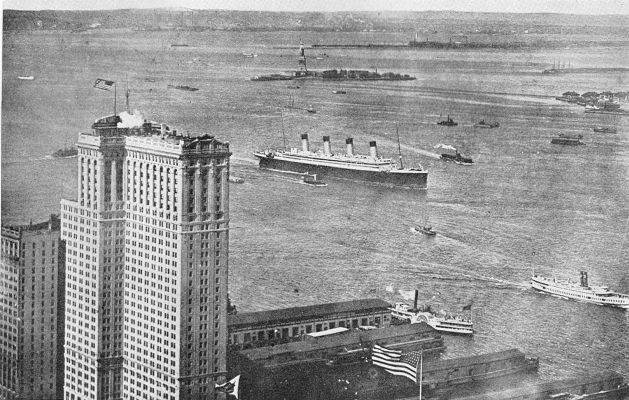 THE BIGGEST LINER IN THE WORLD COMING IN. Ocean steamship with thousands of immigrants on board entering New York harbor; the Statue of Liberty in the distance. (Brown Bros.)