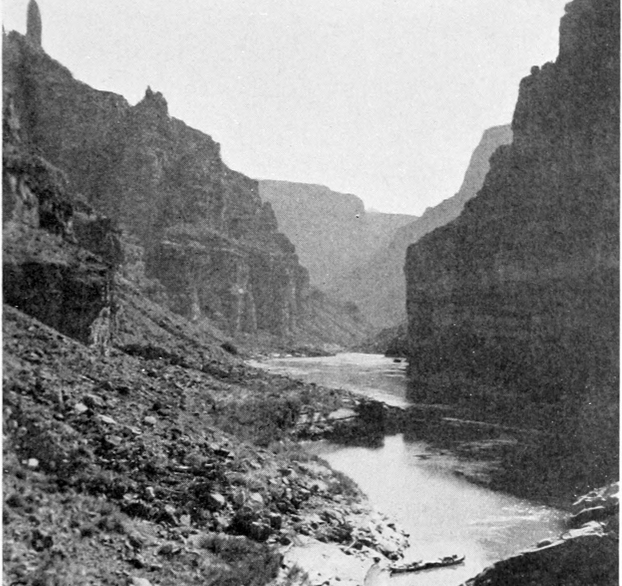 Canyon walls soar upwards from the river. At the bottom of the photo, the Kolb boat are in the water, tied stern to stern.