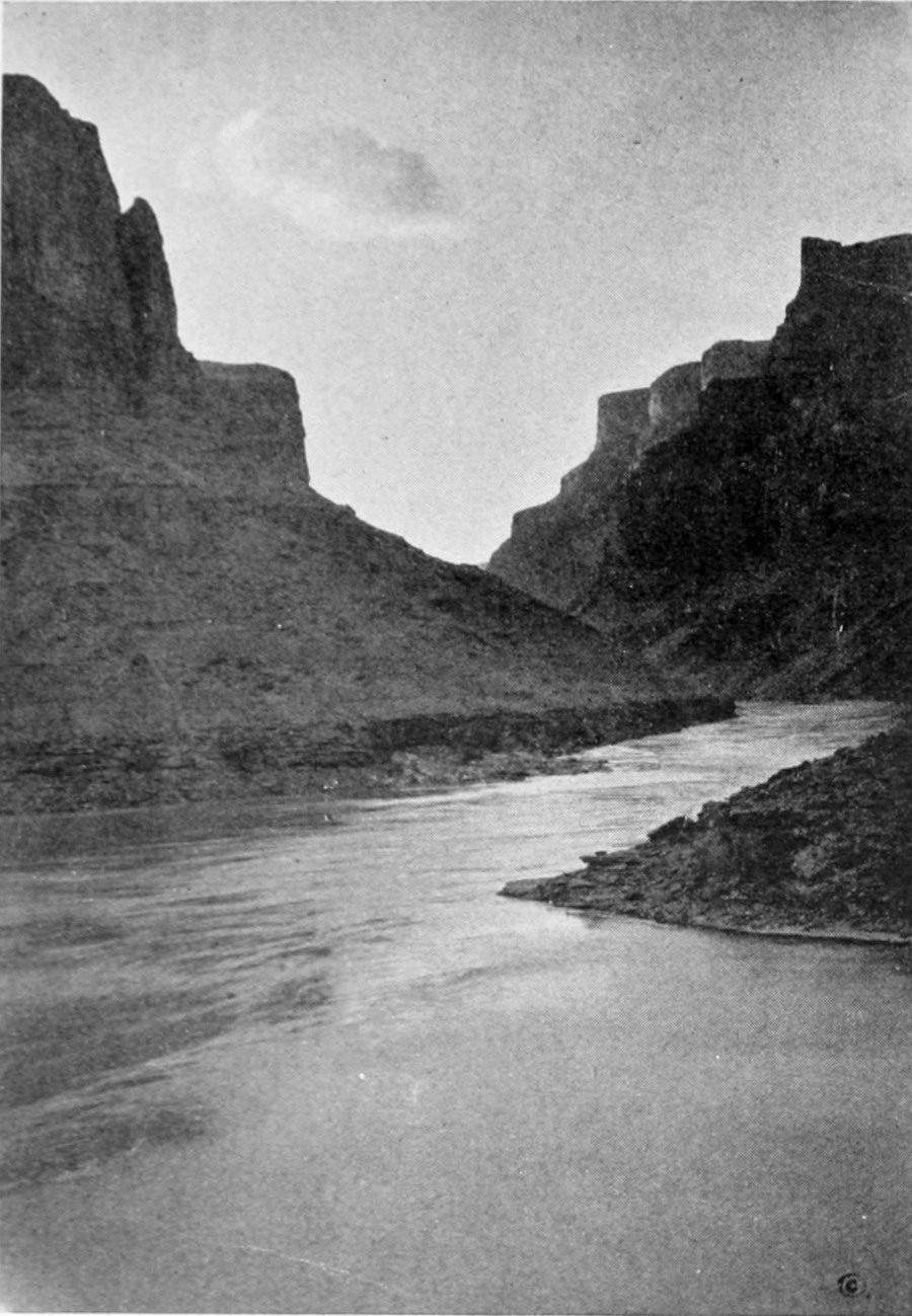 Canyon walls slope away from the calm river, giving a wide view of the sky.