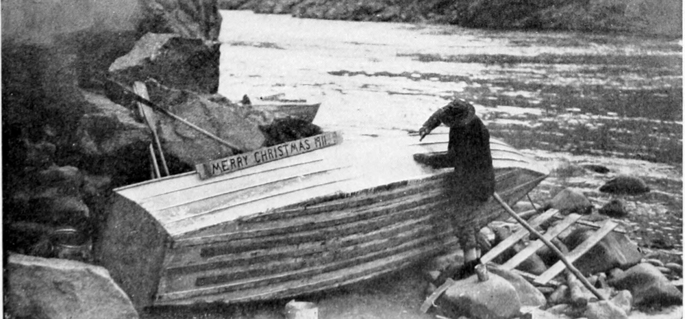 One man repairs the hole in the 'Edith'. A hand-lettered board rests on the side of the boat with the words, 'Merry Christmas 1911.'