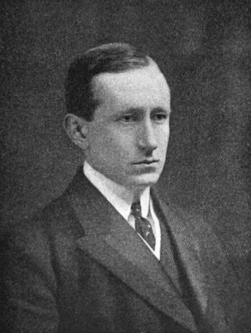 A photograph of a young clean-shaven man in early 20th-century dress — consistent with portraits of Guglielmo Marconi, pioneer of wireless telegraphy and radio communication.