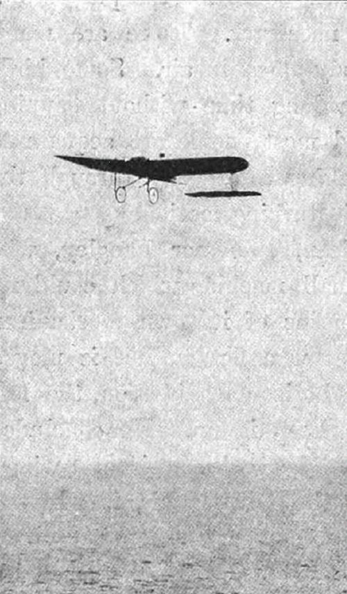 A photograph of an early monoplane in flight over the sea — likely Blériot's crossing of the English Channel in 1909, the first aeroplane flight across it.